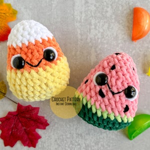 May include: Two crocheted plush toys, a yellow and orange candy corn and a pink and green watermelon, with black eyes and smiling mouths. The text "CROCHET PATTERN INSTANT DOWNLOAD" is on a yellow background.