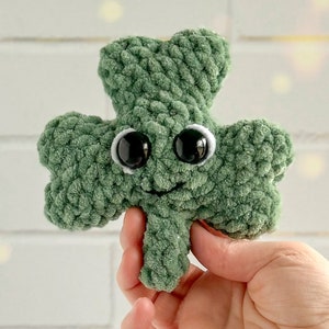 May include: A green crocheted shamrock with googly eyes and a smiling mouth.