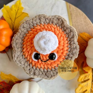 May include: Crochet pattern for a cute pumpkin pie amigurumi with a white whipped cream topping, brown crust, and orange filling. The pattern is available for instant download.