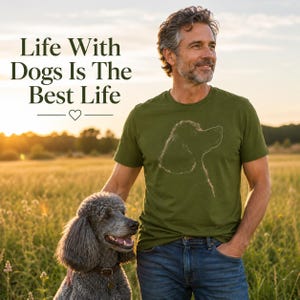 以下が含まれることがあります： 犬の横顔を描いた白い線画が特徴のオリーブグリーンの半袖Tシャツ。シャツには「Life With Dogs Is The Best Life」というテキストと小さなハートのアイコンがプリントされています。デザインは胸の中央に配置されています。