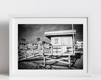 May include: Black and white photograph of a lifeguard stand on a beach. The stand is made of wood and has a sign that reads "Lifeguard on Duty - Keep Off".