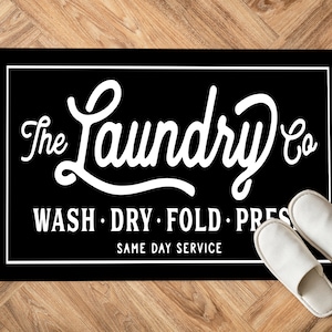 May include: Black and white doormat with the text "The Laundry Co. Wash - Dry - Fold - Press Same Day Service" in a white vintage font.