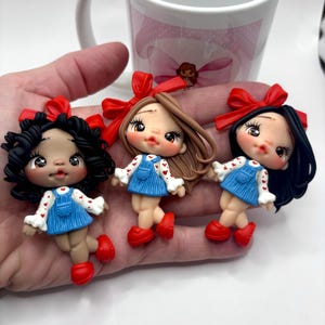 Muñeca de arcilla: centro de lazo hecho a mano, amuleto artesanal, miniatura de arcilla polimérica, regalo de fiesta, muñeca adorable para lazos y decoraciones.