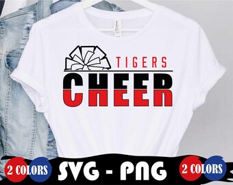 Pode incluir: Camiseta branca com a palavra "CHEER" em letras pretas e vermelhas, e a palavra "TIGERS" em vermelho acima. Um gráfico de pompom em preto e branco está acima da palavra "CHEER". A camiseta está em um cabide branco.