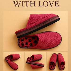 Peut inclure: Des pantoufles rouges avec un motif texturé et des empreintes de pattes noires à l'intérieur. Les pantoufles ont une semelle noire et marron. Le texte "WITH LOVE" est en haut de l'image.
