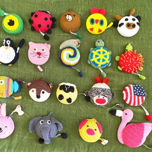 May include: A collection of crocheted animal-shaped measuring tapes. The tapes are in various colours and feature designs such as a ladybug, a turtle, a fox, a flamingo, and a pig.