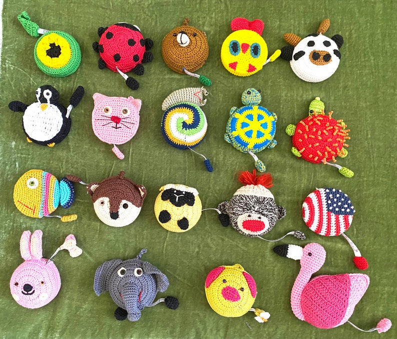 Puede incluir: Una colecci&oacute;n de cintas m&eacute;tricas de crochet con forma de animales. Las cintas son de varios colores y presentan dise&ntilde;os como una mariquita, una tortuga, un zorro, un flamenco y un cerdo.