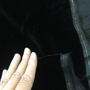 May include: Black velvet fabric with a gold thread running along the edge.