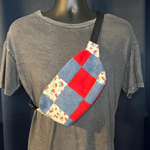 Könnte beinhalten: Eine Patchwork-Bauchtasche mit schwarzem Riemen. Die Tasche hat ein rotes, blaues Denim- und Kirschmuster. Die Bauchtasche wird über der Brust getragen.