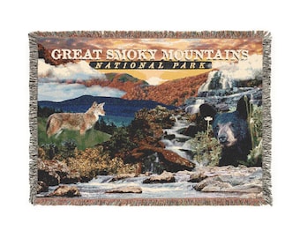 May include: Woven throw blanket featuring a scenic landscape of the Great Smoky Mountains National Park. The design includes a coyote, a black bear, waterfalls, and the text "Great Smoky Mountains National Park."