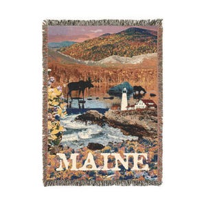 May include: A woven tapestry featuring a scenic landscape of a lake, mountains, and a lighthouse. The tapestry has a moose silhouette in the foreground and the word "MAINE" in white lettering.