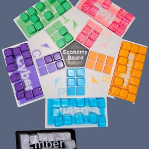 May include: A hexagonal game board with six different colored sections, each with a different word: Cyber, Plasma, Ember,  Solar,  Hot, and  Flora. The center of the board has a black circle with the text "Economy Board".