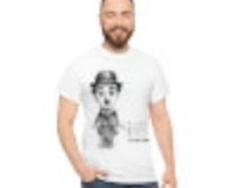 May include: White t-shirt with a black and white illustration of Charlie Chaplin wearing a hat and holding a cane. The text "The Little Tramp" is printed below the illustration.