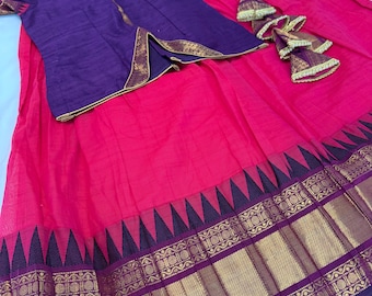 May include: A two-piece outfit consisting of a deep purple short-sleeved top with gold trim and a bright pink floor-length skirt. The skirt features a wide border with a dark purple triangular pattern and intricate gold metallic woven detailing.