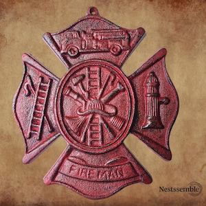 May include: Red cast iron firefighter emblem with a cross design. The emblem features a fire truck, ladder, fire hydrant, and the word "FIREMAN". The emblem is a decorative item.