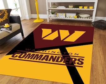 May include: A yellow and burgundy rug with the Washington Commanders logo and the team name "WASHINGTON COMMANDERS" in black lettering.