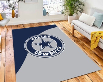 Puede incluir: Una alfombra gris y azul con el logotipo de los Dallas Cowboys en el centro. El logotipo es una estrella blanca dentro de un círculo con las palabras "Dallas Cowboys" alrededor.