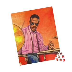 May include: A jigsaw puzzle featuring a painting of a drummer playing a drum set. The drummer is wearing sunglasses, a pink shirt, and suspenders. The drum set is red and gold, set against an orange background. The puzzle is partially assembled.