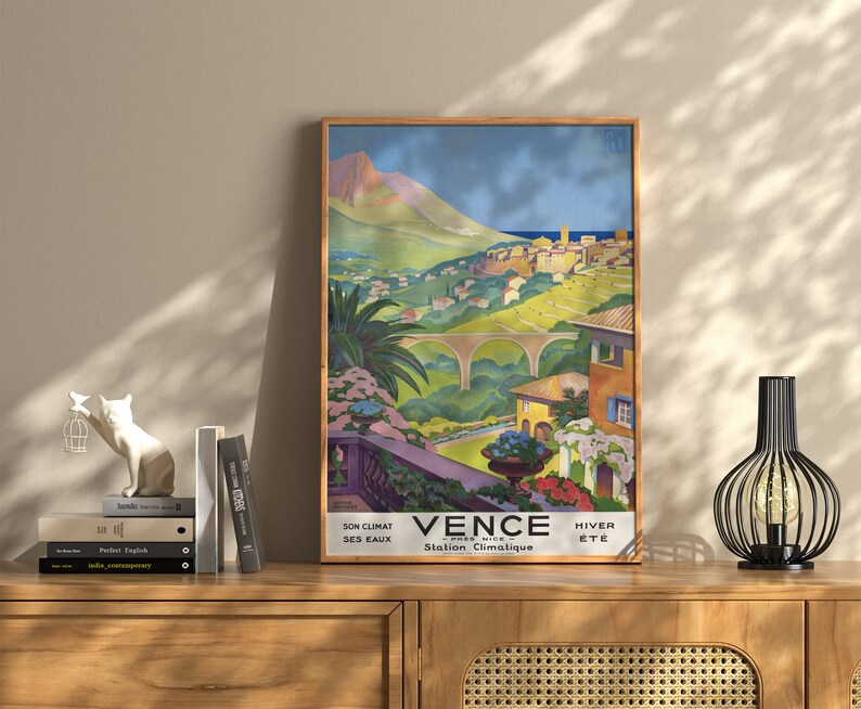 K&ouml;nnte beinhalten: Ein Vintage-Reiseposter, das Vence, Frankreich, als Klimaheilbad bewirbt. Das Poster zeigt eine farbenfrohe Illustration einer Stadt, die in einem Tal eingebettet ist, mit einem Berg im Hintergrund. Der Text auf dem Poster lautet "Vence - Pres Nice - Station Climatique - Son Climat - Ses Eaux - Hiver - Ete".