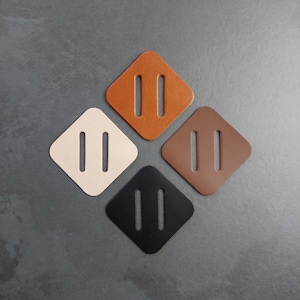 Puede incluir: Cuatro parches de cuero en forma de diamante en diferentes colores: marrón, beige, negro y marrón oscuro. Cada parche tiene dos hendiduras paralelas cortadas.