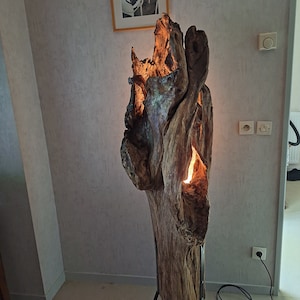 Driftwood lamp on black metal tripods.