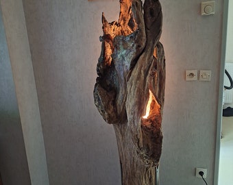 Driftwood lamp on black metal tripods.