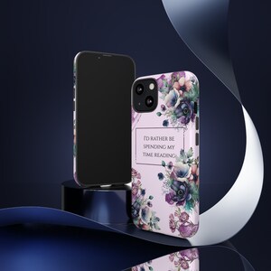 Peut inclure: Une coque de téléphone rose avec un motif floral et le texte "J'aimerais plutôt passer mon temps à lire".