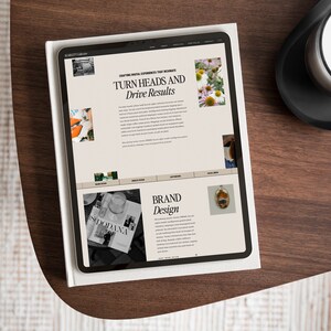 May include: A tablet computer displaying a website with the text "Crafting Digital Experiences That Resonate" and "Turn Heads and Drive Results". The website also features images of flowers, a magazine, and a small, round, framed image.