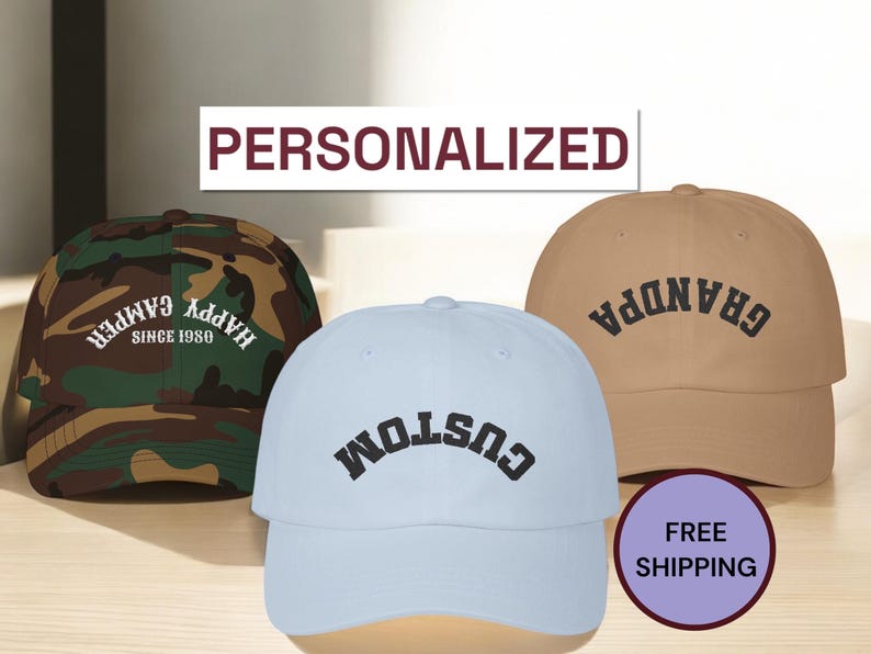 K&ouml;nnte beinhalten: Drei Baseballkappen mit verschiedenen Designs. Die erste Kappe ist Tarnmuster mit dem Text "Happy Camper Since 1980". Die zweite Kappe ist hellblau mit dem Text "Custom" in Schwarz. Die dritte Kappe ist beige mit dem Text "Grandpa" in Schwarz.