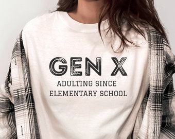 May include: White t-shirt with black text that reads "GEN X ADULTING SINCE ELEMENTARY SCHOOL".