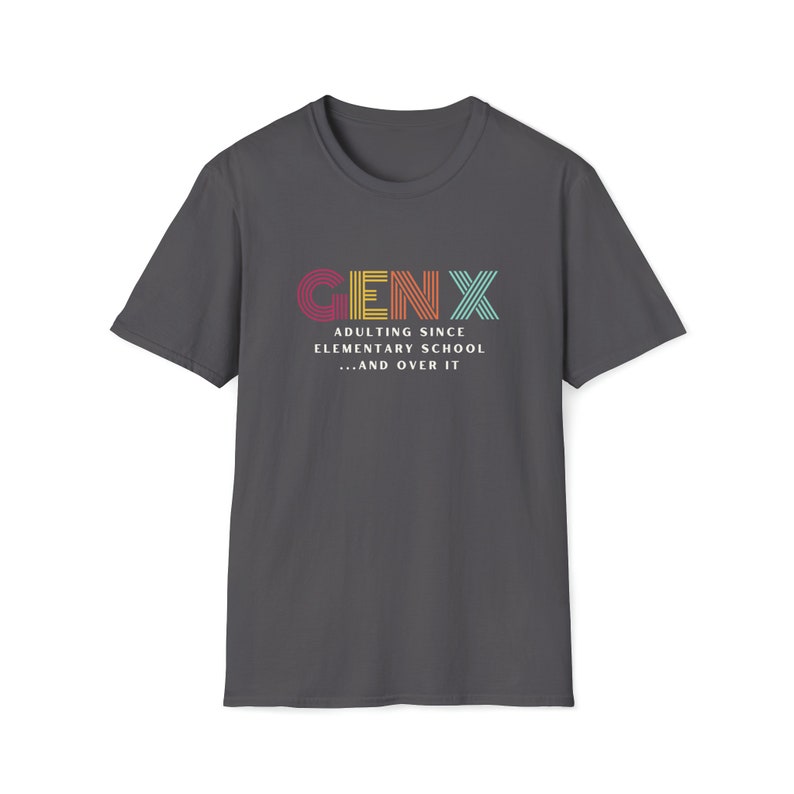 Gildan softstyle tee in Charcoal that says Gen X in colorful large letters over smaller white letters that say Adulting Since Elementary School...and Over It
