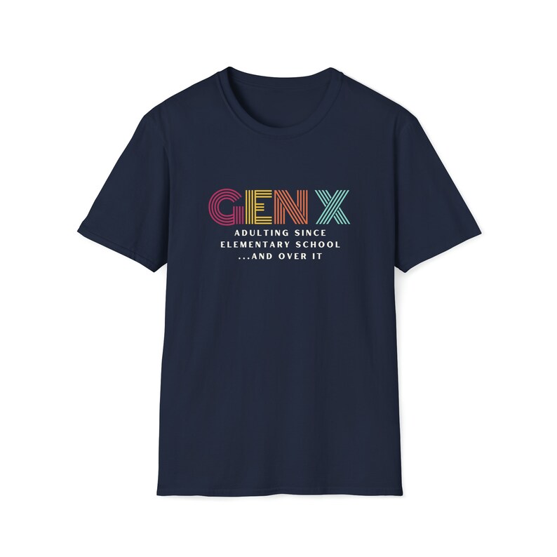 Gildan softstyle tee in Navy blue that says Gen X in colorful large letters over smaller white letters that say Adulting Since Elementary School...and Over It