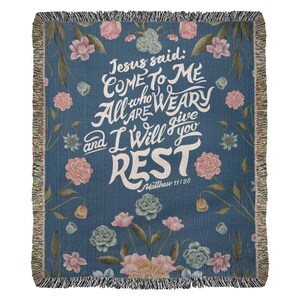 K&ouml;nnte beinhalten: Eine gewebte Wolldecke mit blauem Hintergrund und floralem Muster. Der Text "Jesus sagte: Kommt zu mir, alle, die ihr m&uuml;hselig und beladen seid, so will ich euch Ruhe geben" ist in Wei&szlig; mit floralem Design geschrieben. Der Text "Matth&auml;us 11:28" ist in kleinerer wei&szlig;er Schrift unter dem Haupttext geschrieben.