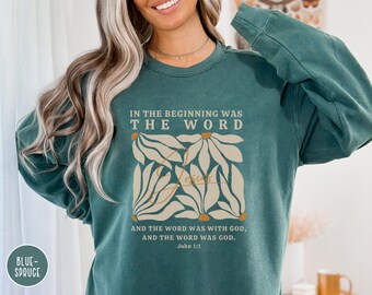 May include: Teal blue sweatshirt with a floral design and the text "In the beginning was the word" and "And the word was with God, and the word was God. John 1:1"
