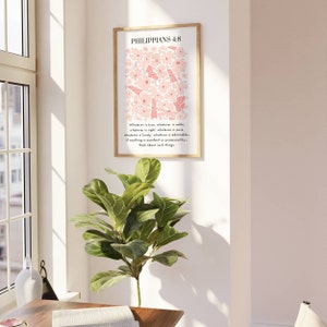 May include: A framed print with a white background and pink flowers and butterflies. The print features the text "Philippians 4:8" and a quote from the Bible: "Whatever is true, whatever is noble, whatever is right, whatever is pure, whatever is lovely, whatever is admirable - if anything is excellent or praiseworthy - think about such things."