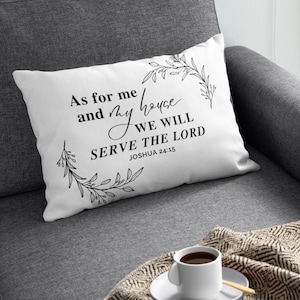 Op de afbeelding: Wit kussen met zwarte tekst en bloemenpatroon. De tekst luidt "As for me and my house we will serve the Lord Joshua 24:15".