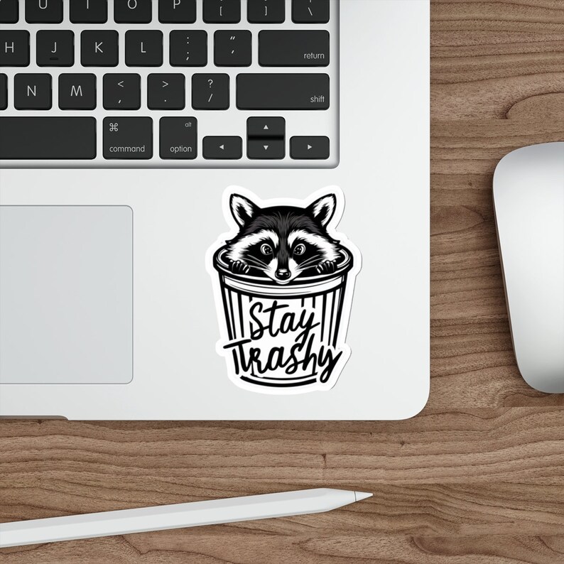 Water resistant feral raccoon trash panda funny die cut sticker with Stay Trashy slogan, perfect for laptops, tumblers, water bottles, journals, and more! Raccoon gifts for animal lovers in their feral era.