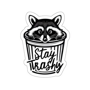 Water resistant feral raccoon trash panda funny die cut sticker with Stay Trashy slogan, perfect for laptops, tumblers, water bottles, journals, and more! Raccoon gifts for animal lovers in their feral era.