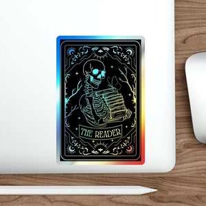Holographic tarot card sticker featuring a skeleton holding a stack of books with a butterfly atop, surrounded by celestial stars and tree branches. Perfect for laptops, journals, water bottles, and scrapbooks. Ideal gift for readers and book lovers.