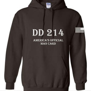 May include: A dark brown hooded sweatshirt with the text "DD 214 AMERICA'S OFFICIAL MAN CARD" in white. An American flag graphic is on the right sleeve. The sweatshirt has a front pocket and a drawstring hood.
