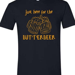 May include: Black t-shirt with orange text that reads "Just here for the Butterbeer" and a graphic of two mugs of butterbeer.