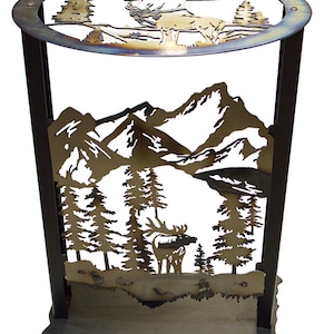 May include: A metal side table with a nature-themed design. The table features cut-out silhouettes of mountains, trees, and moose. The top is a circular shape with a similar design. The table is approximately 24 inches tall.