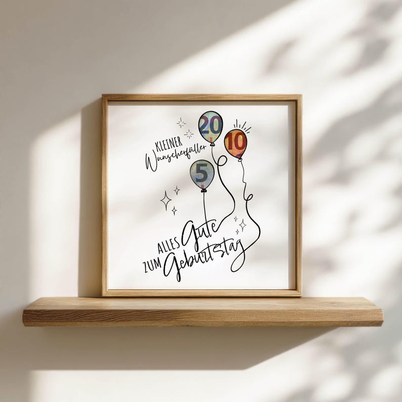 May include: A framed print with a wooden frame featuring three balloons with the numbers 5, 10, and 20. The print has the text "Kleiner Wunscherf&uuml;ller" and "Alles Gute zum Geburtstag" in black script.