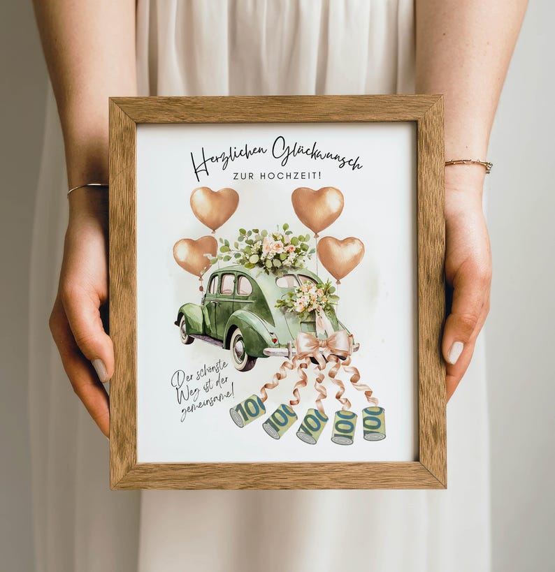 May include: A framed print featuring a green vintage car decorated with flowers and a bow, with heart-shaped balloons. The print includes German text and illustrations of money. The frame is made of wood.