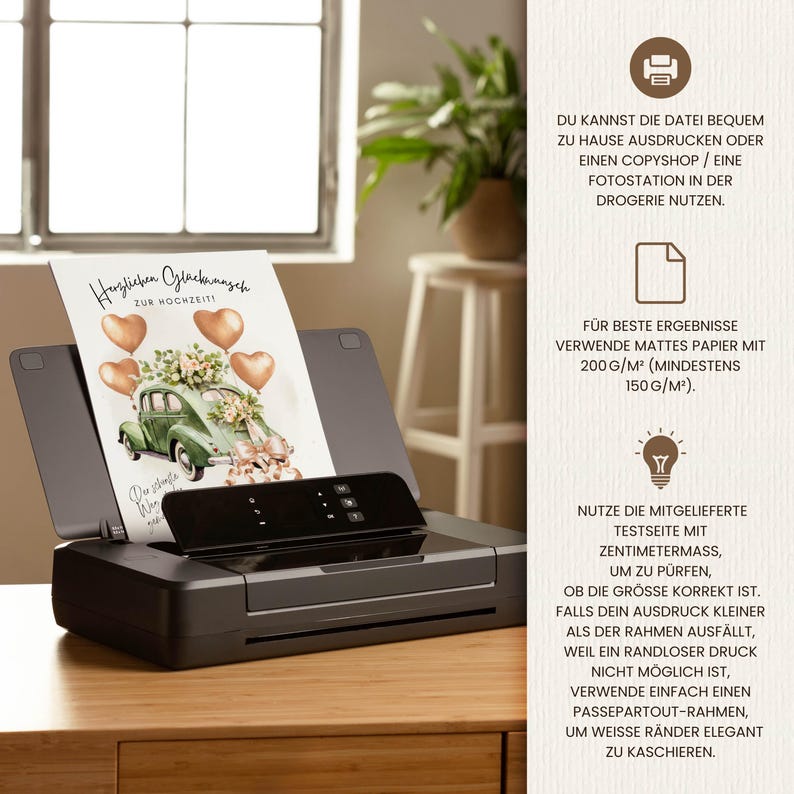 May include: A black inkjet printer with a printed wedding card featuring a vintage green car, heart-shaped balloons, and floral arrangements. The card reads "Herzlichen Gl&uuml;ckwunsch zur Hochzeit". The printer sits on a wooden surface.