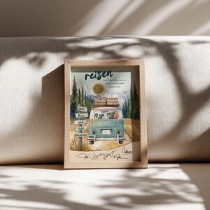 May include: A framed print featuring a teal vintage van with luggage on its roof, driving through a mountain landscape. The artwork includes a wooden signpost, a compass, and the German text "reisen macht das Leben reicher, auch wenn das Konto kleiner wird" along with "gute Reise und viele Abenteuer" and handwritten signatures at the bottom.