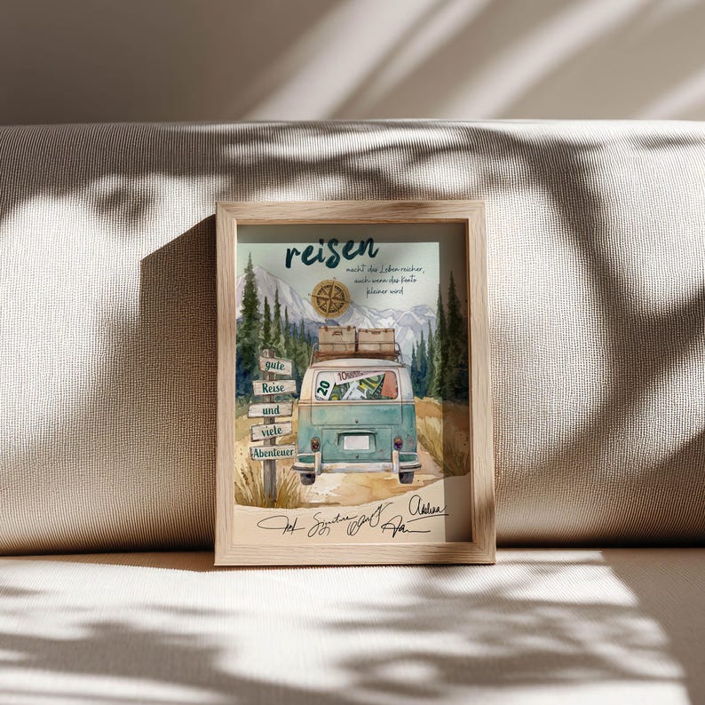 May include: A framed print featuring a teal vintage van with luggage on its roof, driving through a mountain landscape. The artwork includes a wooden signpost, a compass, and the German text "reisen macht das Leben reicher, auch wenn das Konto kleiner wird" along with "gute Reise und viele Abenteuer" and handwritten signatures at the bottom.