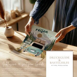 May include: A printed poster featuring a watercolour illustration of a teal camper van, pine trees, mountains, and a compass. The text reads "reisen macht das Leben reicher, auch wenn das Konto kleiner wird" and "gute Reise und viele Abenteuer".