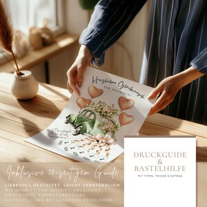 May include: A wedding-themed print featuring a vintage green car decorated with flowers and ribbons, accompanied by heart-shaped balloons. The print includes German text, with additional text at the bottom and a separate guide with tips and extras.