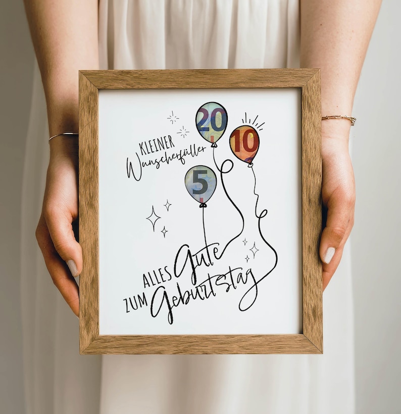 May include: A framed print with a wooden frame. The print features three balloons with the numbers 5, 10, and 20, along with German text. The balloons are in shades of blue, orange, and green. The text includes the phrase "Alles Gute zum Geburtstag."
